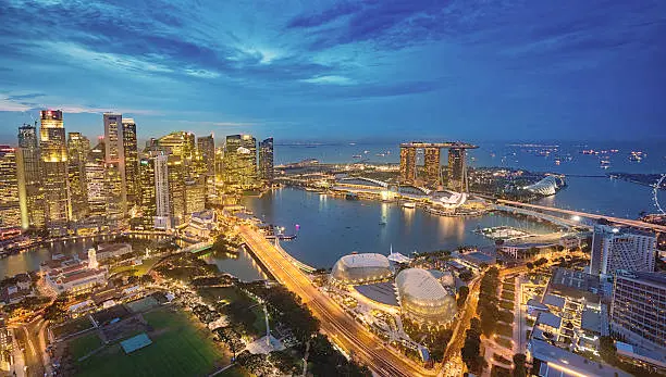 Panoramic view of Singapore's skyline from Sands SkyPark Observation Deck at Marina Bay Sands, showcasing the iconic landmarks and glittering lights of the city.